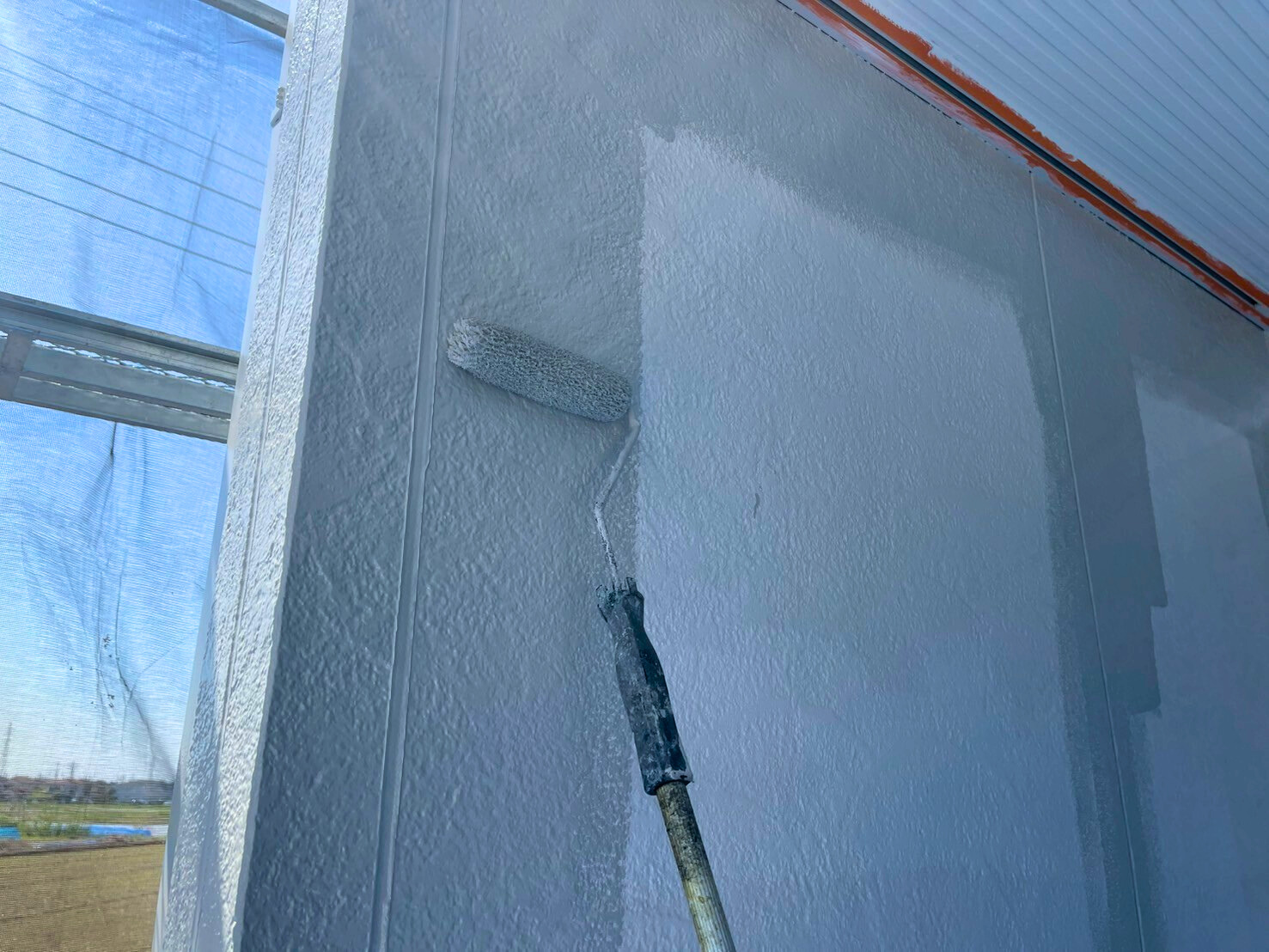 外壁塗装中の従業員